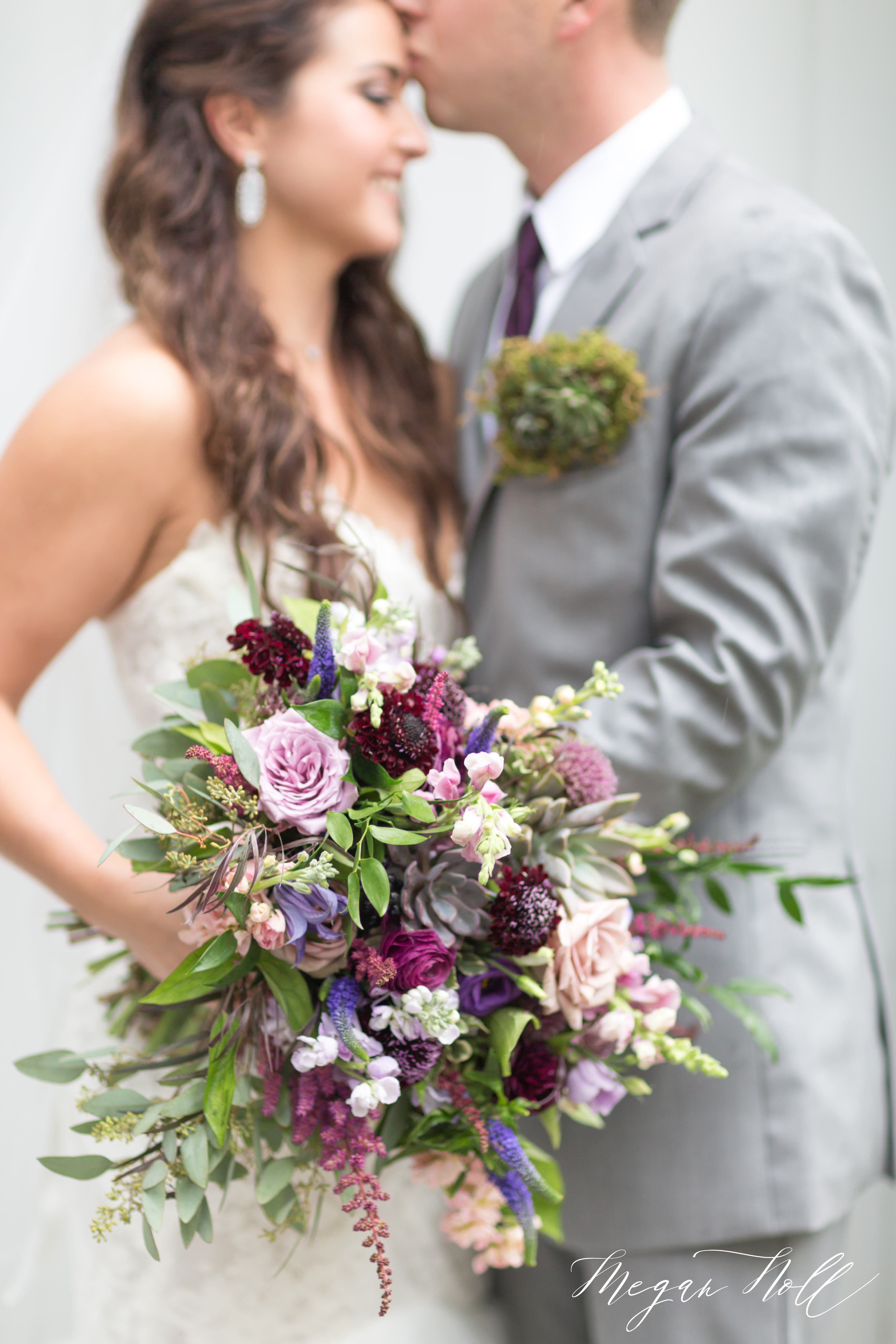 Brides bouquet with groom kissing forehead