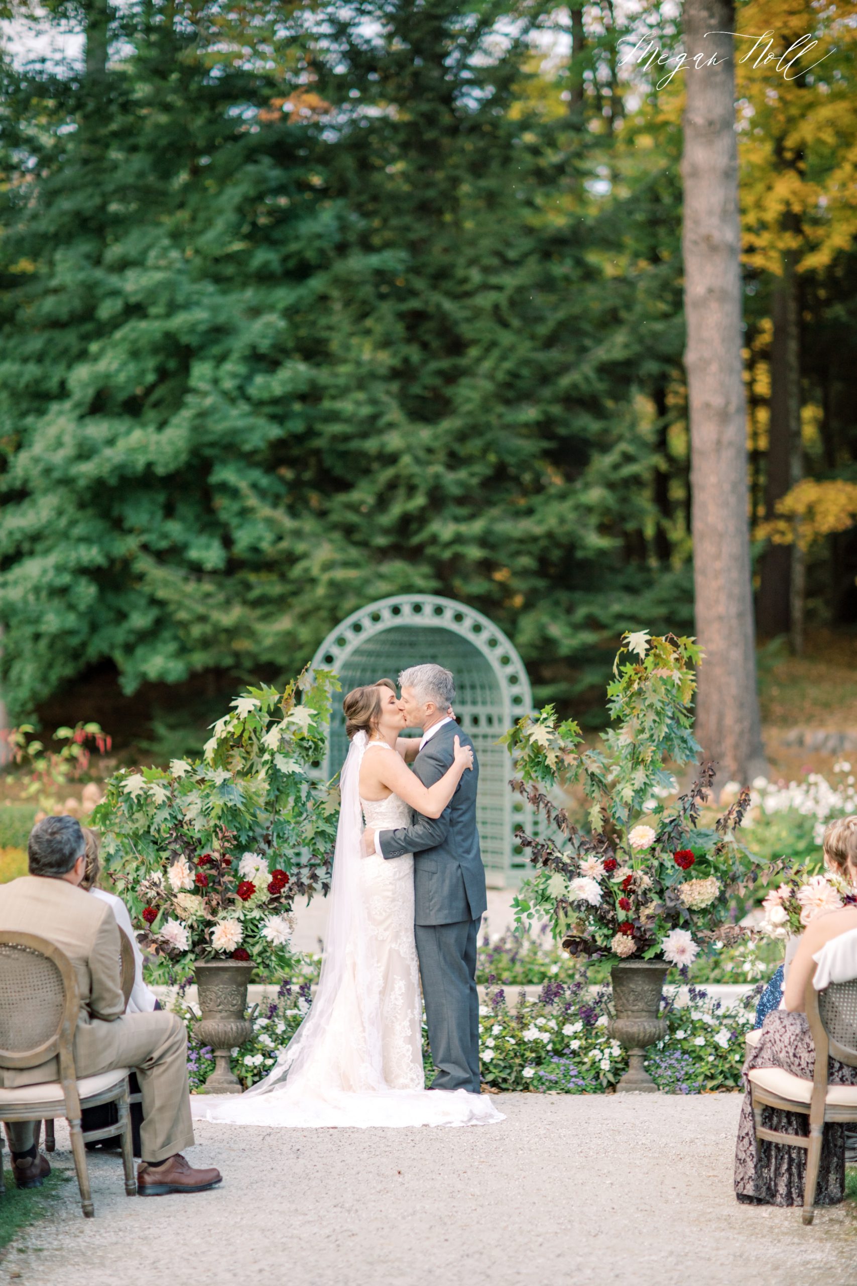 First kiss in outdoor fall wedding ceremony at Edith Wharton Mansion