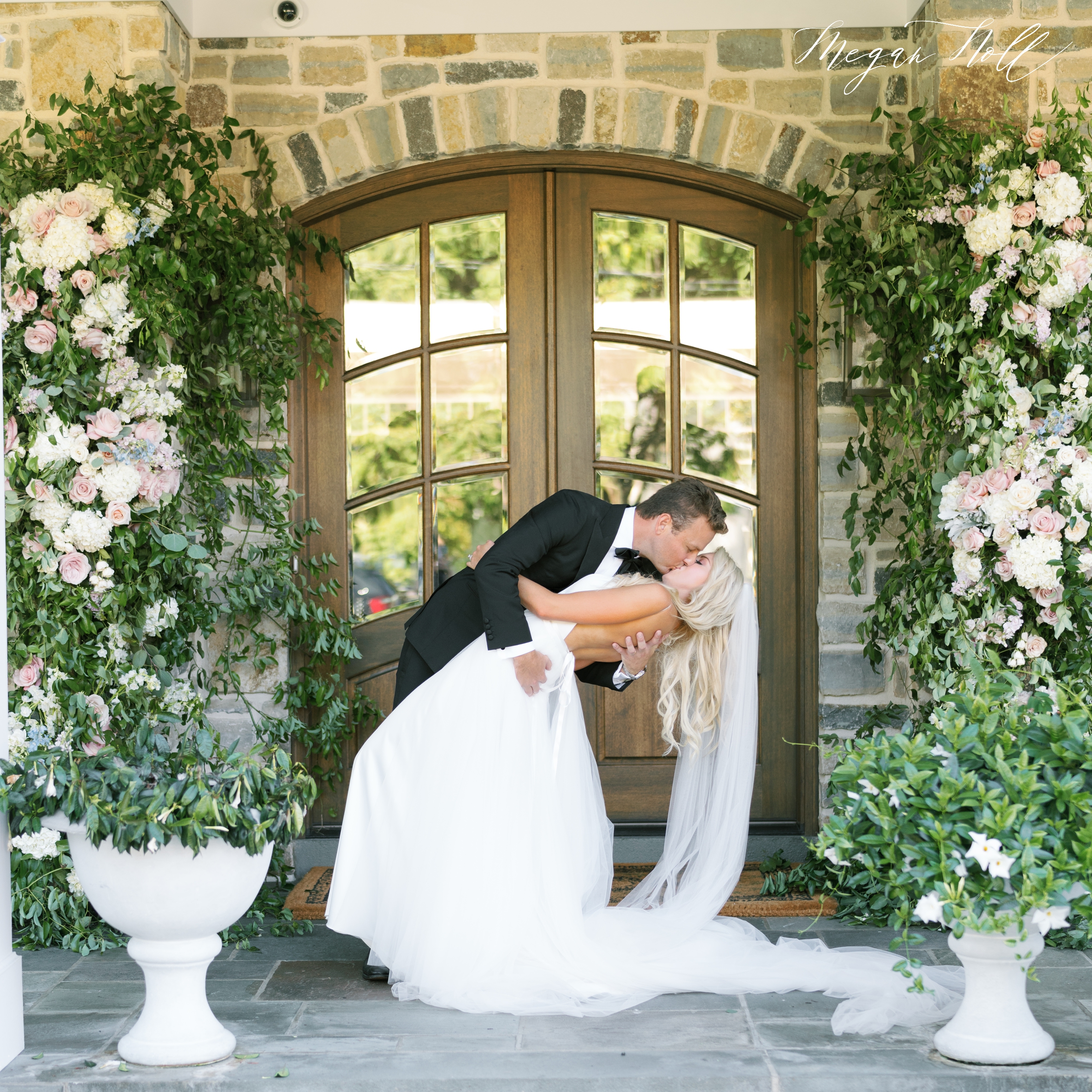 Bride and groom dipping in front of floral arch by Marti Heard Designs