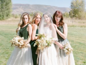 Bride poses with bridesmaids at beautiful ranch wedding
