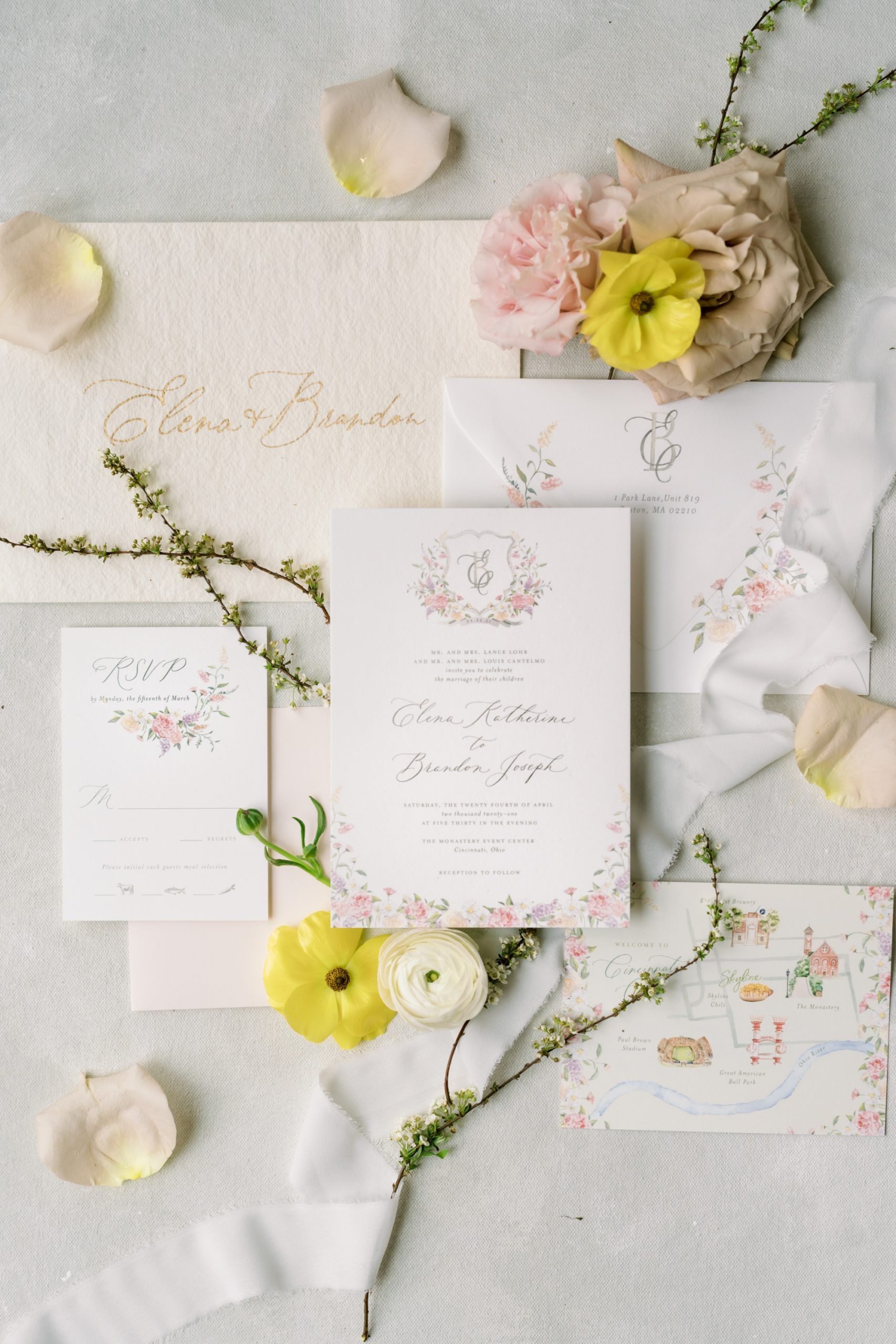 Wedding detail flatlay with the wedding invitation suite and blooms