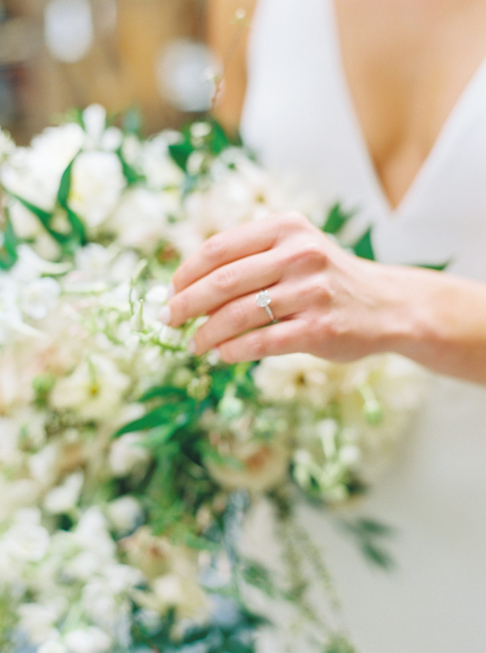Close up image of the bride's engagement ring and wedding bouquet