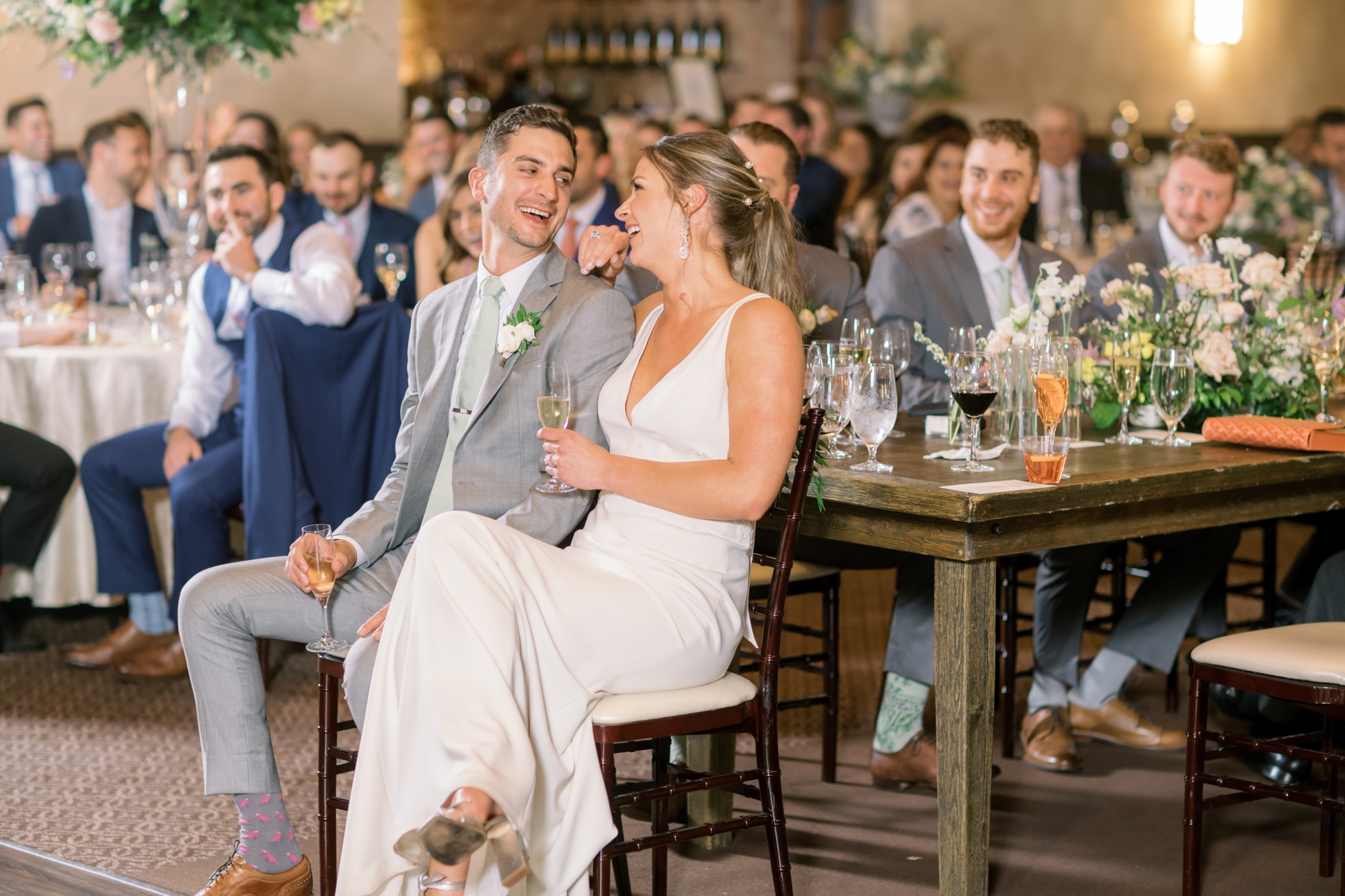 bride and groom smile during wedding toasts