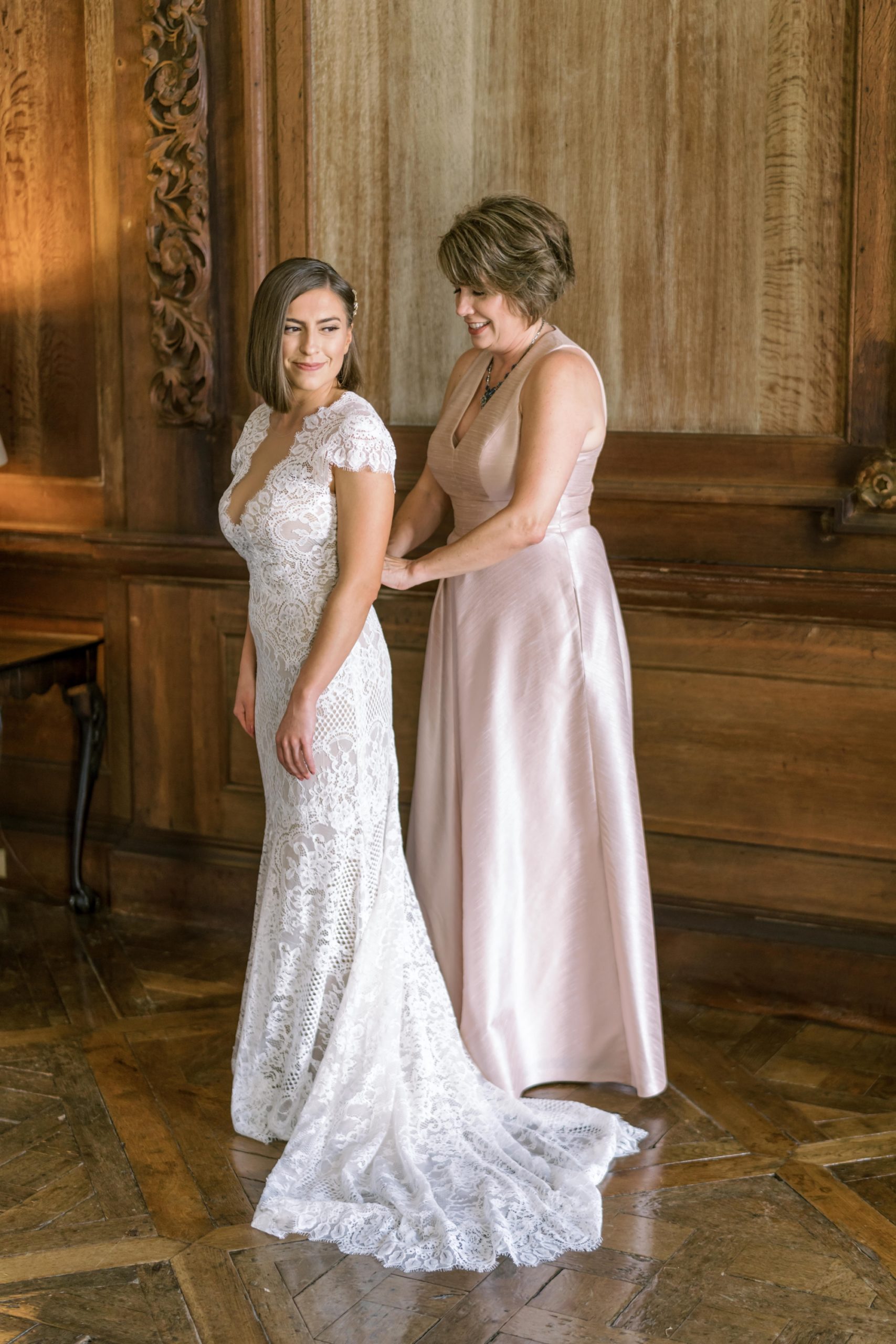 the mother of the bride helped the bride into her wedding dress