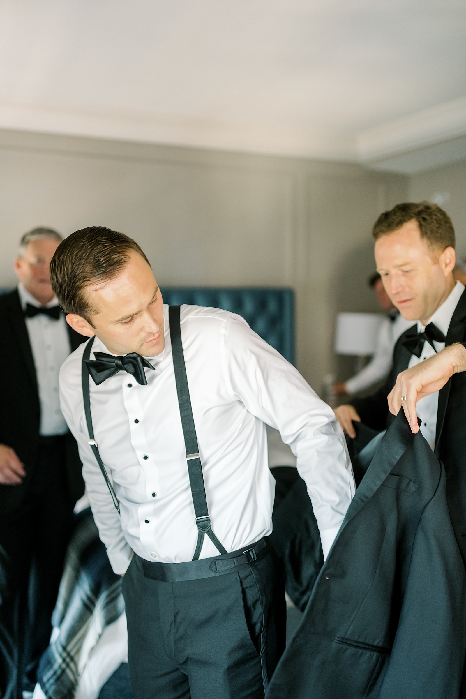 Groom putting on Tux Jacket before Cincinnati Wedding