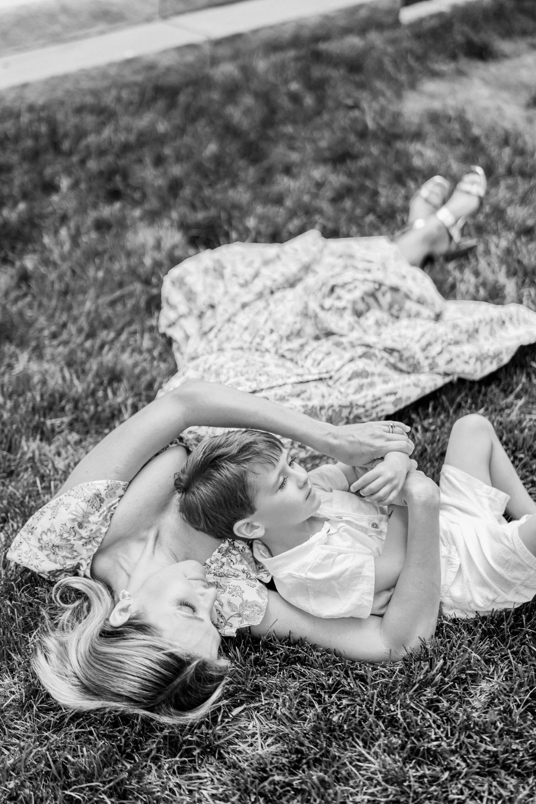 Mother and son lay in the grass during family photo session at home