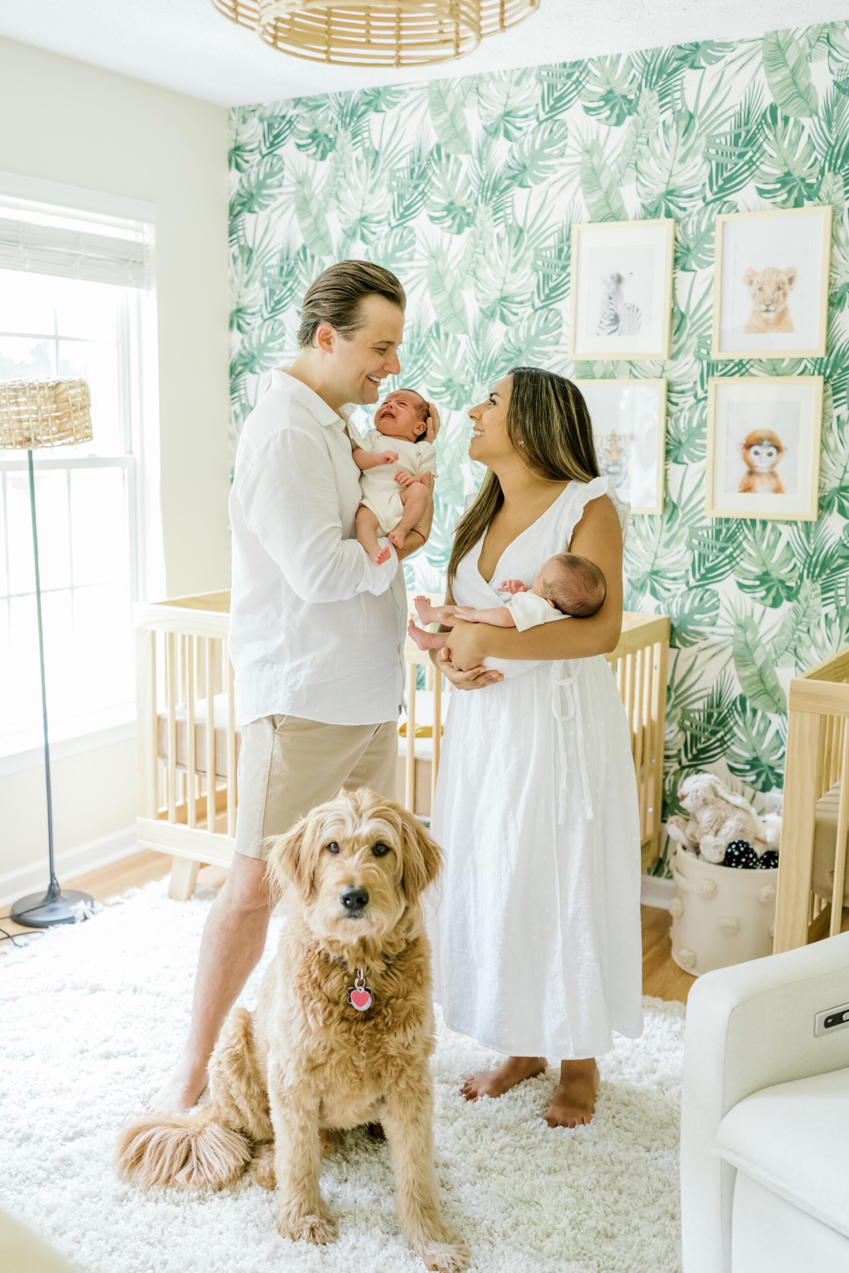 Mom and dad hold newborn twins during newborn photography session